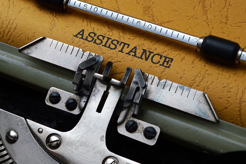 Typewriter with the word Assistance typed on the paper.