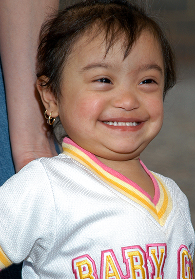 Young girl in white shirt with Baby Girl spelled out.